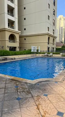 a swimming pool in front of a building at AMWAJ JBR Walk Beachfront Apt in Dubai