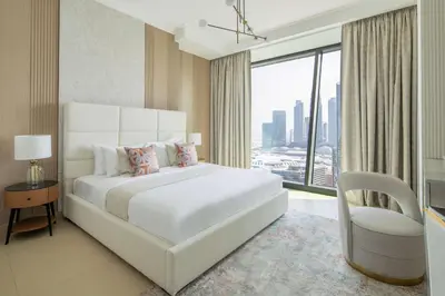 a bedroom with a large white bed and a chair at Frank Porter - Burj Vista 1 in Dubai