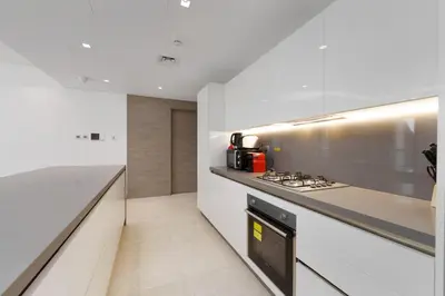 a kitchen with white counters and a stove top oven at Business Bay Exquisite Living Experience-Suiteable in Dubai