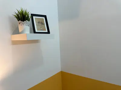a wall with a picture and a plant on it at Wonderful Partition Room in Al Barsha 1 Near Metro in Dubai
