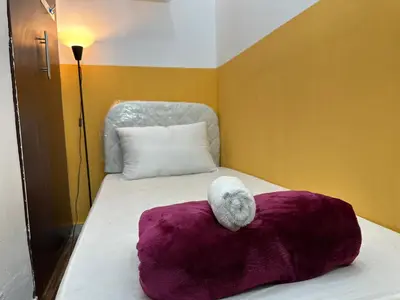 a white stuffed animal sitting on top of a bed at Wonderful Partition Room in Al Barsha 1 Near Metro in Dubai