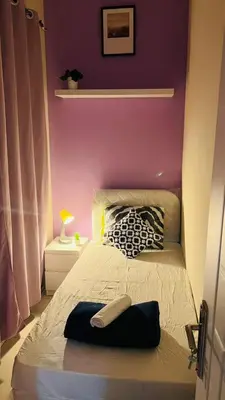 a bedroom with a bed with a purple wall at Peaceful Partition Room Near Mall of the Emirates in Dubai