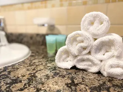 a pile of towels sitting on a bathroom counter at JBR Beach Full Sea View 2 BR High Floor in Dubai