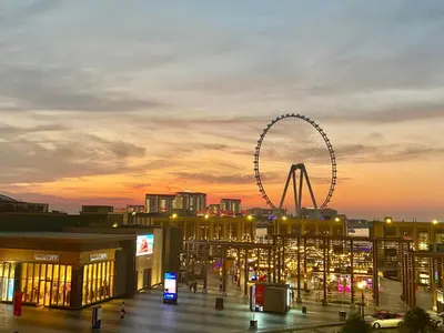 a ferris wheel in a city at sunset at JBR Beach Full Sea View 2 BR High Floor in Dubai