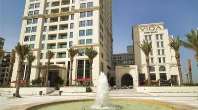 a fountain in front of a hotel with a building at Luxury 1BR Retreat @ Vida Residences - Creek Beach in Dubai