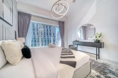 a white bedroom with a large bed and a mirror at Wondrous 1BR at DAMAC Heights Dubai Marina by Deluxe Holiday Homes in Dubai