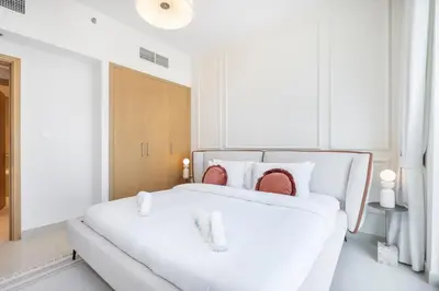 a white bedroom with a large white bed at Elegant apartment in Dubai Creek Harbour in Dubai