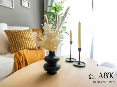a table with two candles and a vase on it at Near Burj Khalifa NYE Brand New Cozy 1BR Business Bay in Dubai