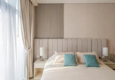 a bedroom with a large bed with two blue pillows at Studio with pool and private beach access on Palm Jumeirah in Dubai
