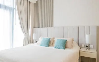 a bedroom with a white bed with blue pillows at Studio with pool and private beach access on Palm Jumeirah in Dubai