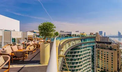 a balcony with chairs and a bridge on a building at Studio with pool and private beach access on Palm Jumeirah in Dubai