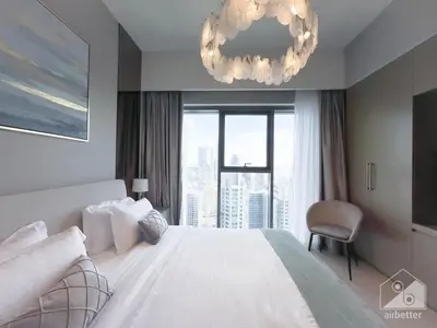 a bedroom with a white bed and a chandelier at Luxury Burj Royale Apt balcony & Breathtaking View in Dubai