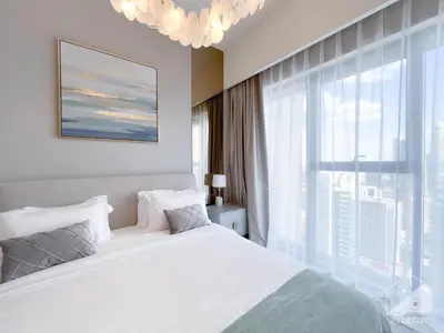 a bedroom with a white bed and a large window at Luxury Burj Royale Apt balcony & Breathtaking View in Dubai