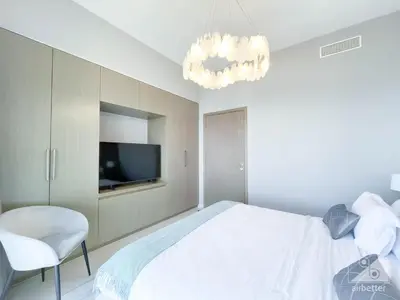 a bedroom with a bed and a television and a chandelier at Luxury Burj Royale Apt balcony & Breathtaking View in Dubai