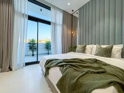 a bedroom with a large bed and a large window at Bright New Studio with Pool & Gym Access, 5 min from Gardens Metro in Dubai