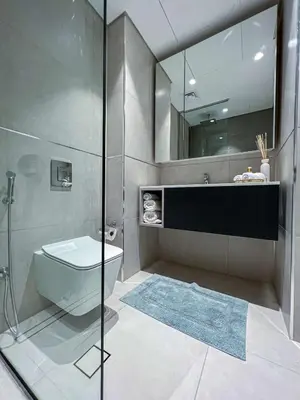 a bathroom with a toilet and a sink and a mirror at Bright New Studio with Pool & Gym Access, 5 min from Gardens Metro in Dubai