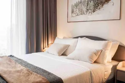 a bed with white sheets and pillows in a bedroom at Brand new 2 BR in Boulevard with partial Burj Khalifa and Opera View in Dubai