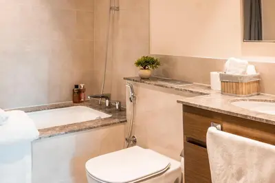 a bathroom with a tub and a toilet and a sink at Brand new 2 BR in Boulevard with partial Burj Khalifa and Opera View in Dubai