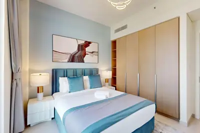 a bedroom with a large bed and two lamps at Summer at Creek Beach - Elegant One Bedroom in Dubai