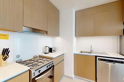 a kitchen with a stove top oven next to a sink at Summer at Creek Beach - Elegant One Bedroom in Dubai