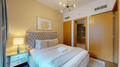 a bedroom with a large white bed and a lamp at Iris Blue - Neat One Bedroom in Dubai