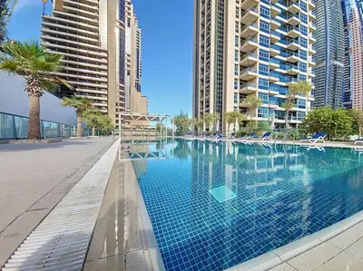 a swimming pool in a city with tall buildings at Iris Blue - Neat One Bedroom in Dubai