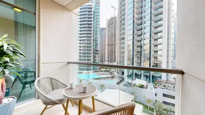 a balcony with a table and chairs and a view of a city at Iris Blue - Neat One Bedroom in Dubai