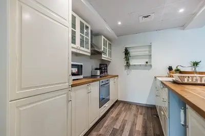 a kitchen with white cabinets and a wooden floor at Serene & Spacious 1BR The Greens in Dubai