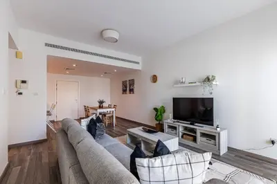 a living room with a couch and a tv at Serene & Spacious 1BR The Greens in Dubai
