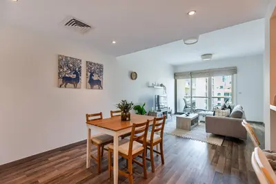 a living room with a table and a couch at Serene & Spacious 1BR The Greens in Dubai