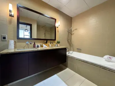 a bathroom with a large mirror and a tub and a sink at Manzil - 3BR in Palm Jumeirah with Private Beach Access & Sea View in Dubai