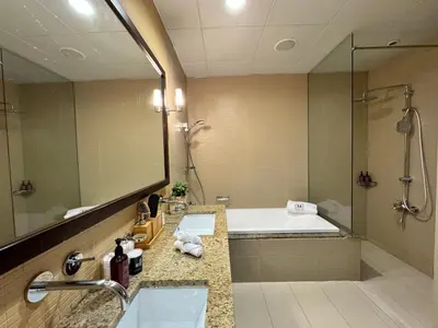 a bathroom with two sinks and a tub and a mirror at Manzil - 3BR in Palm Jumeirah with Private Beach Access & Sea View in Dubai