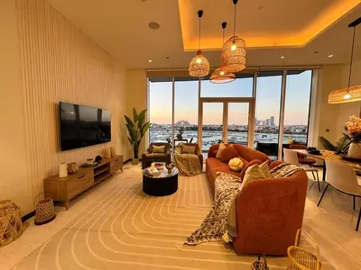 a living room with a couch and a tv and a table at Manzil - 3BR in Palm Jumeirah with Private Beach Access & Sea View in Dubai