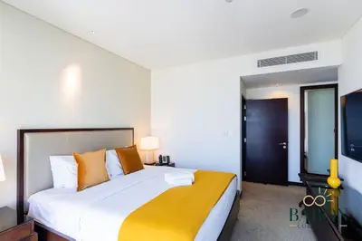 a bedroom with a large white bed with orange pillows at The Sophisticated Suite in Dubai