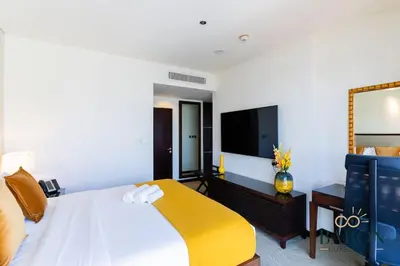 a bedroom with a bed and a flat screen tv at The Sophisticated Suite in Dubai