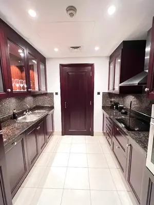 a kitchen with dark wood cabinets and a sink at SmartApt Elegant 1 BDR Burj view in Dubai
