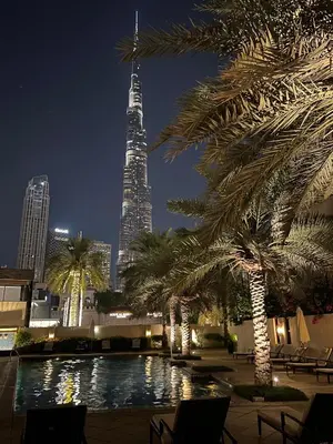 a view of the burj khalifa at night with palm trees at SmartApt Elegant 1 BDR Burj view in Dubai