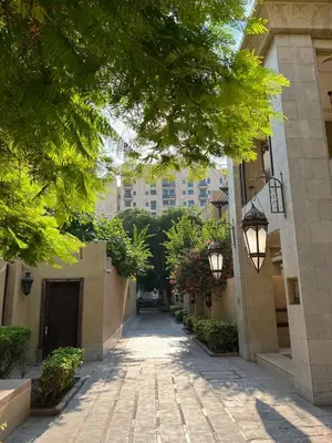 an alley with trees and buildings in a city at SmartApt Elegant 1 BDR Burj view in Dubai