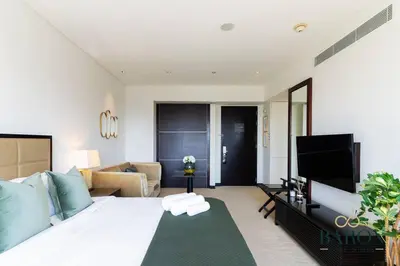 a bedroom with a large bed and a living room at The Stylish in Dubai