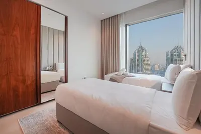 a hotel room with two beds and a large window at Luxe Living: Spacious Waterfront 2BR in Marina Gate in Dubai