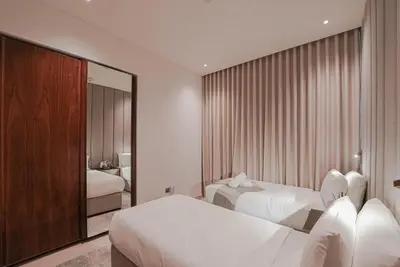 a hotel room with two beds and a mirror at Luxe Living: Spacious Waterfront 2BR in Marina Gate in Dubai