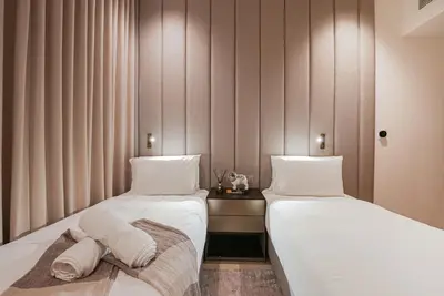 two beds sitting next to each other in a room at Luxe Living: Spacious Waterfront 2BR in Marina Gate in Dubai