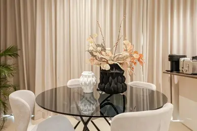 a glass table with a vase of flowers on it at Luxe Living: Spacious Waterfront 2BR in Marina Gate in Dubai