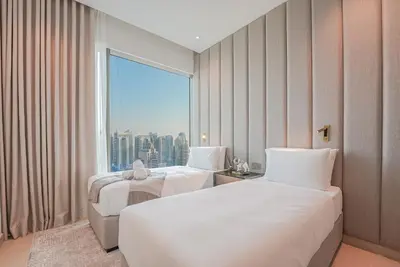 a hotel room with two beds and a large window at Luxe Living: Spacious Waterfront 2BR in Marina Gate in Dubai