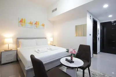 a bedroom with a bed and a table and chairs at Studio Apartment in Merano Tower by The S Holiday Homes in Dubai