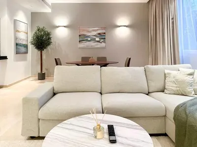 a living room with a couch and a table at Upgraded 1BR Paradise With Private Garden - Oceana in Dubai