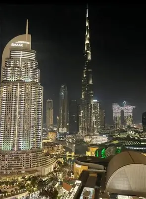 a city skyline at night with a tall building at Address Fountain View Tower 2 in Dubai