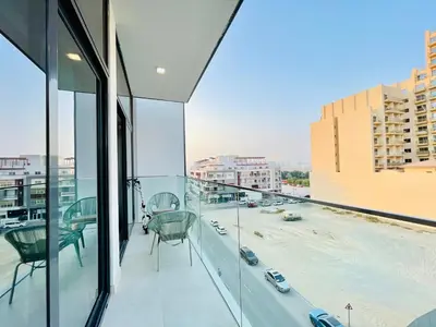 a balcony with chairs and a view of a city at Luxury 1 Bedroom Apartment in Dubai