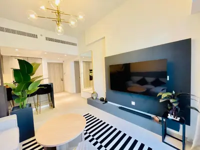 a living room with a blue wall with a tv at Luxury 1 Bedroom Apartment in Dubai