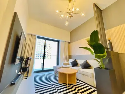 a living room with a white couch and a table at Luxury 1 Bedroom Apartment in Dubai